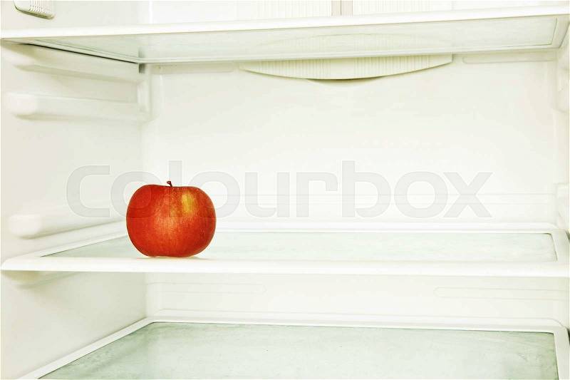 Red single apple in domestic refrigerator taken closeup. Toned image, stock photo