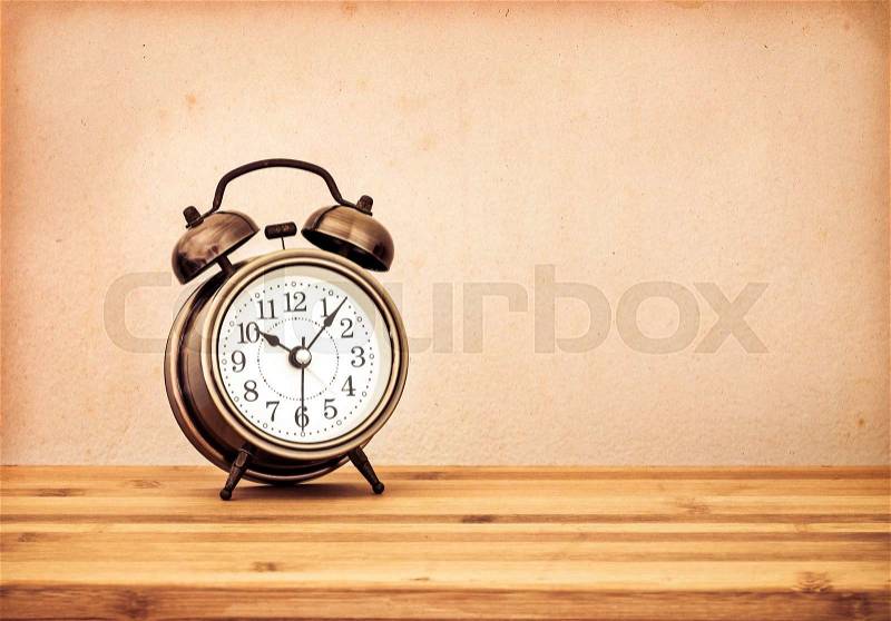 The retro and vintage style of Old fashioned the alarm clock on wooden table, stock photo