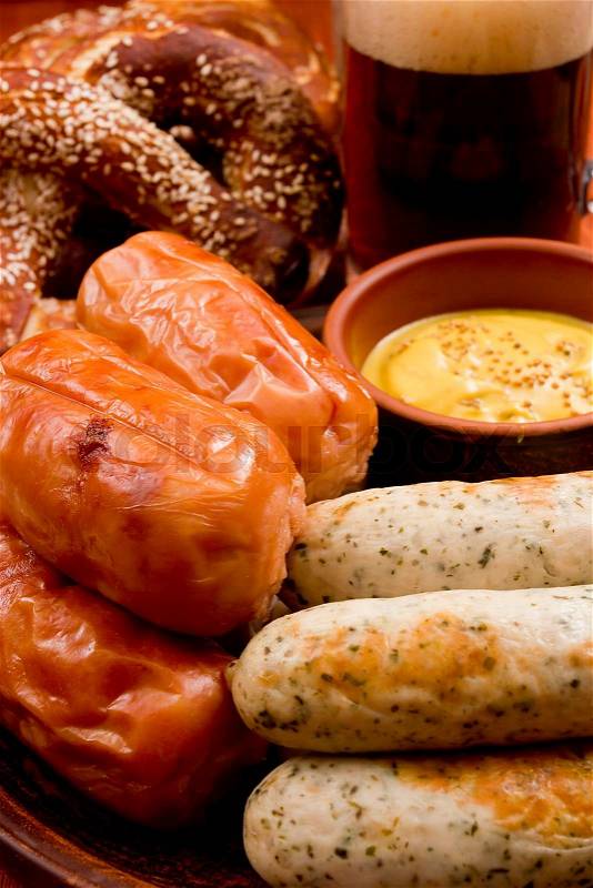 Traditional sausages, pretzels and beer on a wooden background, stock photo
