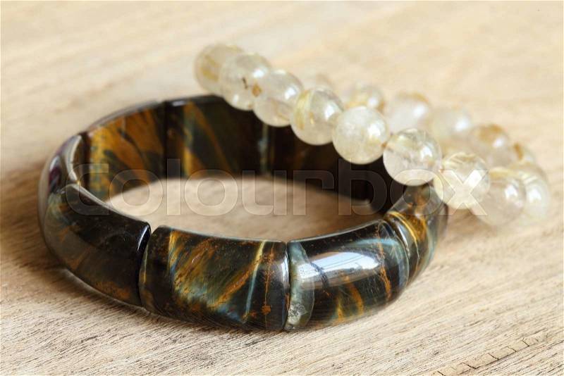 Lucky stone bracelets on wood background, closeup image, stock photo