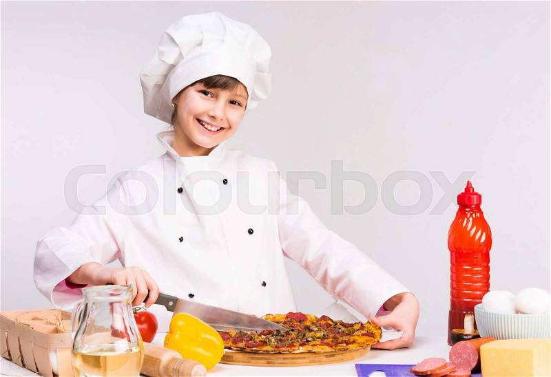 Little smiling girl-cook in uniform with big pizza in hands, stock photo