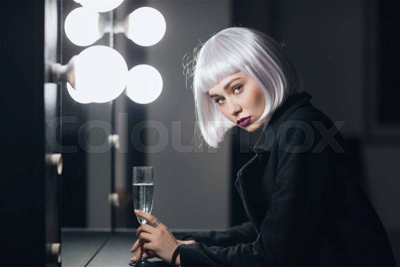 Beautiful woman drinking champaigne in dressing room, stock photo