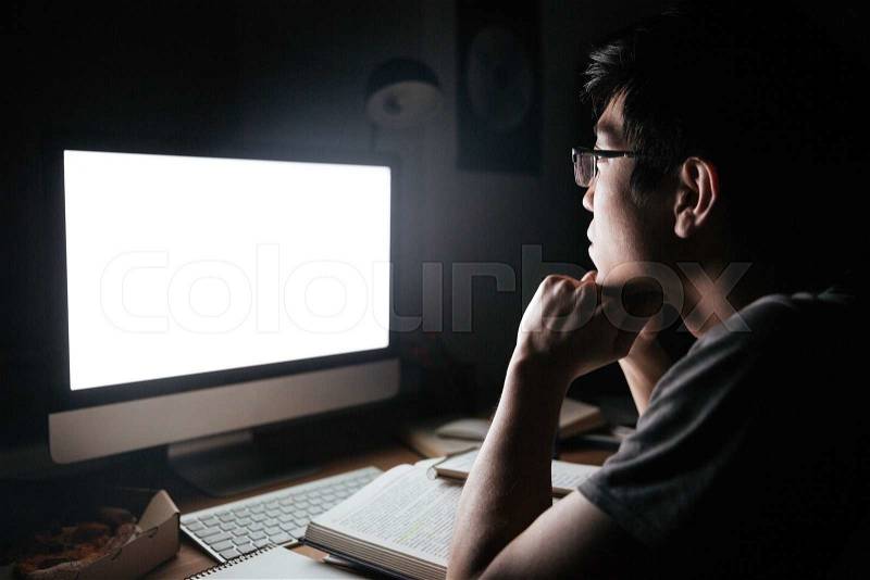 Man in glasses studying using blank screen computer, stock photo