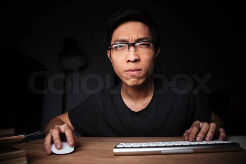 Concentrated man in glasses working with computer, stock photo