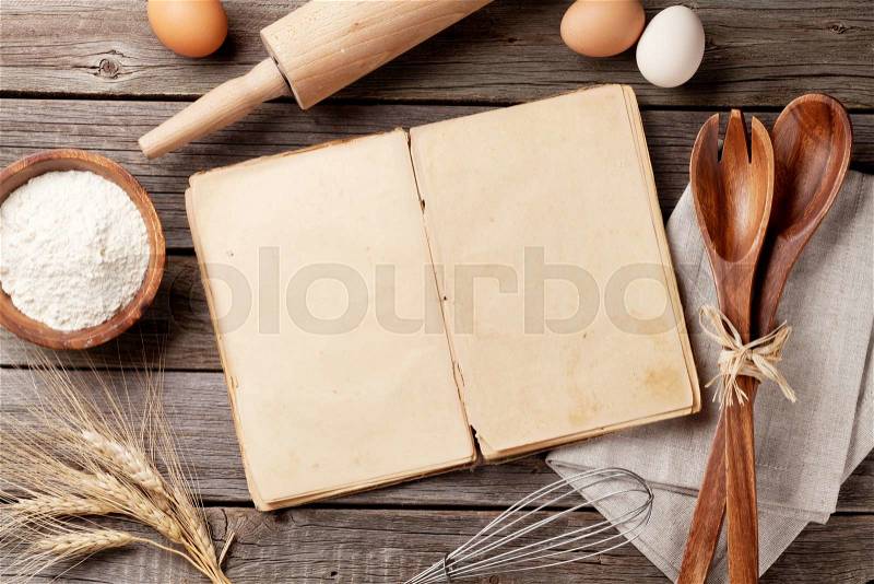 Blank vintage recipe cooking book, utensils and ingredients on wooden table. Top view with copy space, stock photo