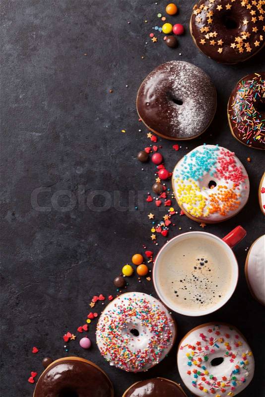 Colorful donuts and coffee on stone table. Top view with copy space, stock photo