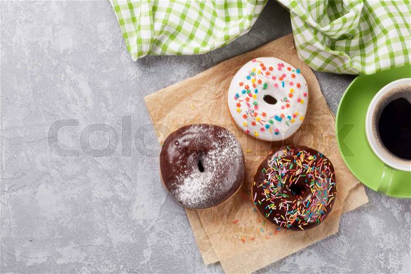 Colorful donuts and coffee on stone table. Top view with copy space, stock photo