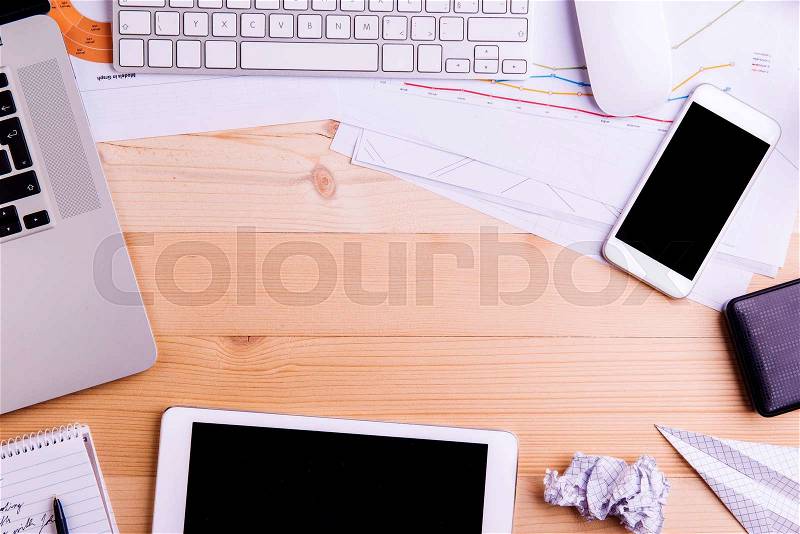 Desk with gadgets and office supplies. Tablet, smart phone and stationery around the workplace. Flat lay. Studio shot on wooden background. Copy space, stock photo