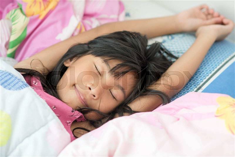 Asian girl sleeping on bed covered with blanket, stock photo