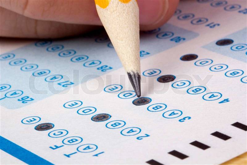 Student filling out answers to a test with a pencil, stock photo