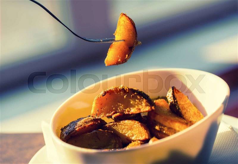 Potato. Roasted potato. Crispy potatoes. Potato wedges roasted in their skins. Portion of american potatoes in hotel home or restaurant. Golden and crispy potato. Toned photo, stock photo