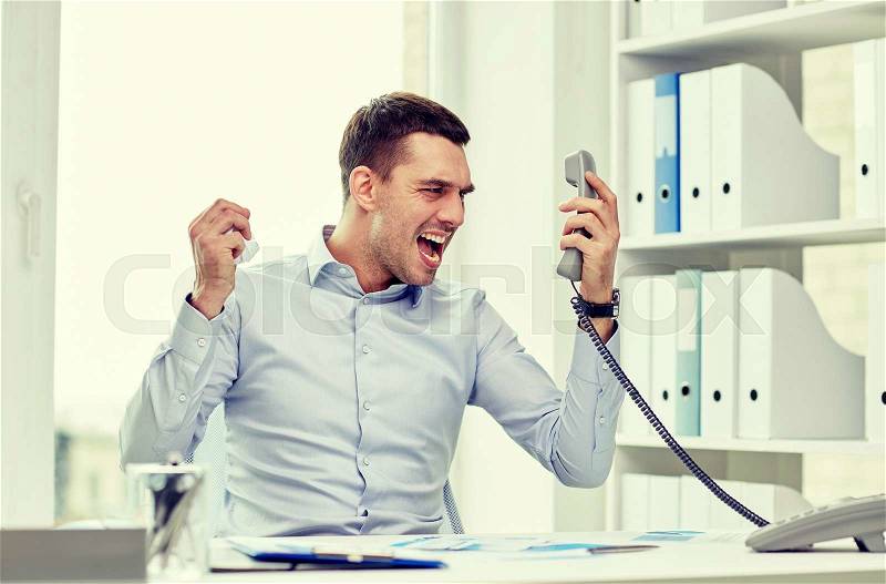 Business, people, emotions, stress and communication concept - furious businessman calling on phone in office, stock photo