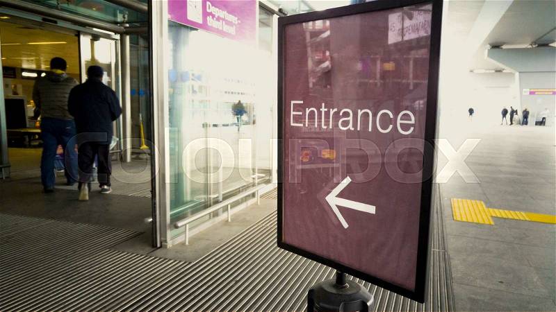 Entrance sign at modern airport with automatic glass doors, stock photo