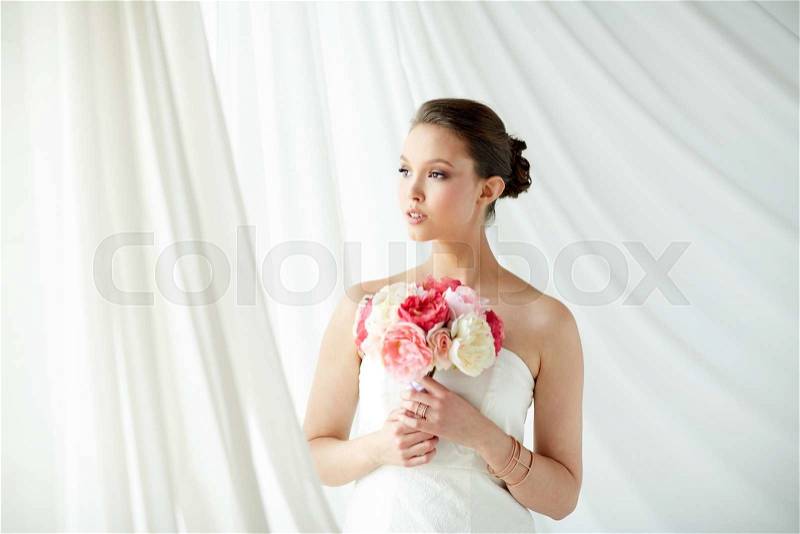 Beauty, jewelry, people and luxury concept - beautiful asian woman or bride in white dress with peony flower, golden ring and bracelet, stock photo