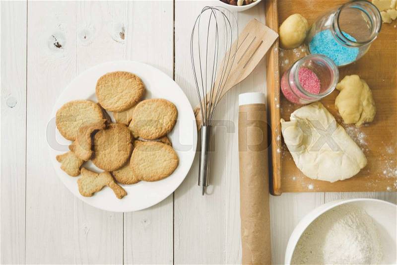 View from above on cooked cookies on dish and kitchen utensils on table, stock photo