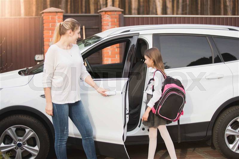 Young mother meeting daughter after school lessons, stock photo