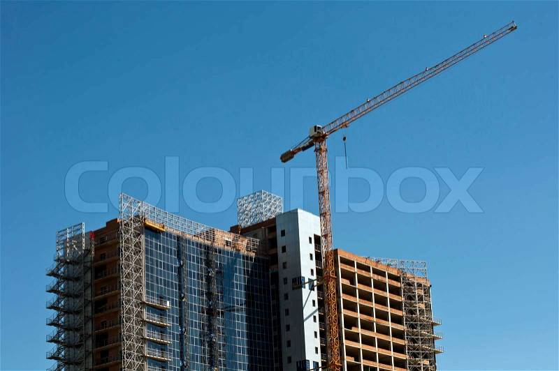Building. Crane towering over the concrete structure, stock photo