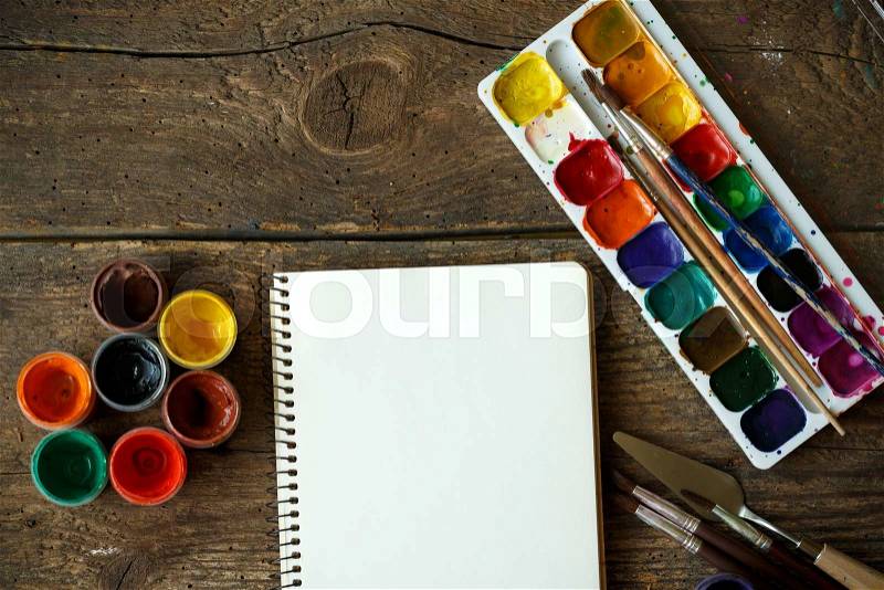 Art of Painting. Painting set: paper, brushes, paints, watercolor, acrylic paint on a wooden background top down view, stock photo