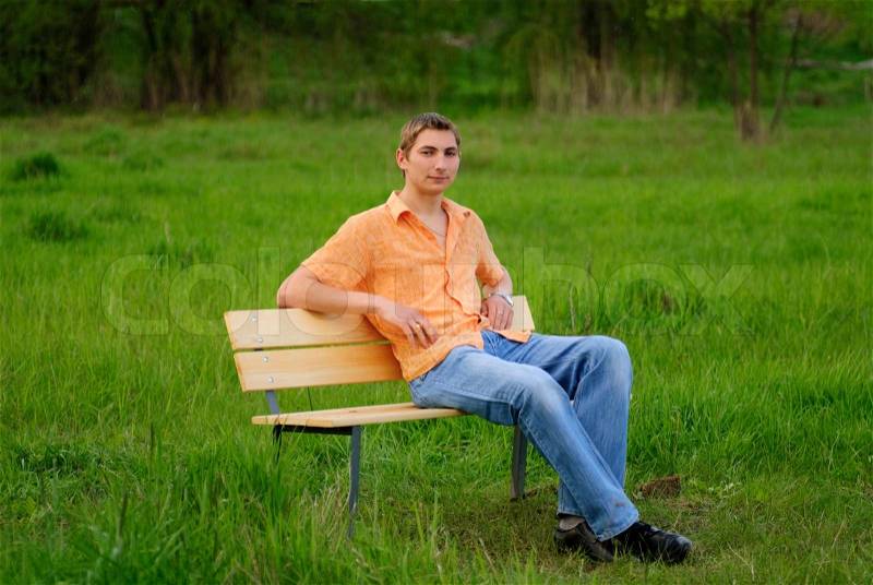 Man on bench in park. Shallow DOF. Outdoor portrait, stock photo