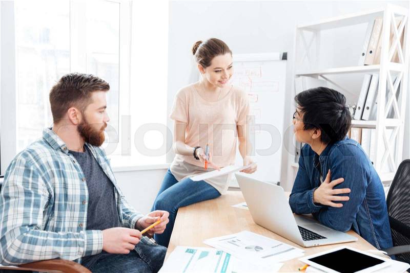 Concentrated young businesspeople working and making new project in office together , stock photo