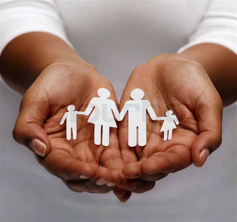 Life insurance, love and charity concept - closeup of womans cupped hands showing paper man family, stock photo