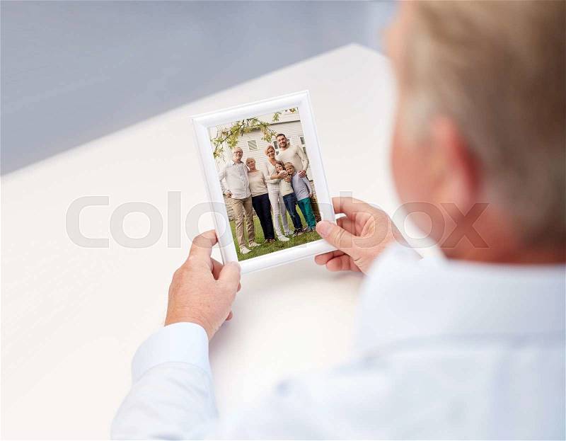 Oldness, memories, nostalgia and people concept - close up of old man holding and looking at happy family photo, stock photo