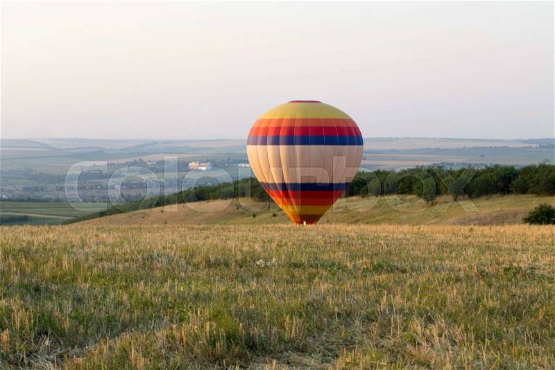 Landing balloon. The balloon lands in a field. Rural landscape, stock photo