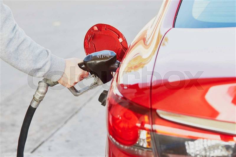 Pumping gas at gas pump. Closeup of man pumping gasoline fuel in car at gas station, stock photo