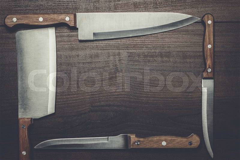 Kitchen knifes on the brown wooden table, stock photo