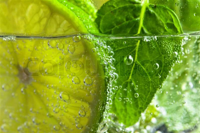 cocktail with lime , ice and peppermint leaves , stock photo