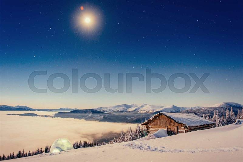 Footpath in winter mountains leading to the chalets and yurts under the stars, stock photo