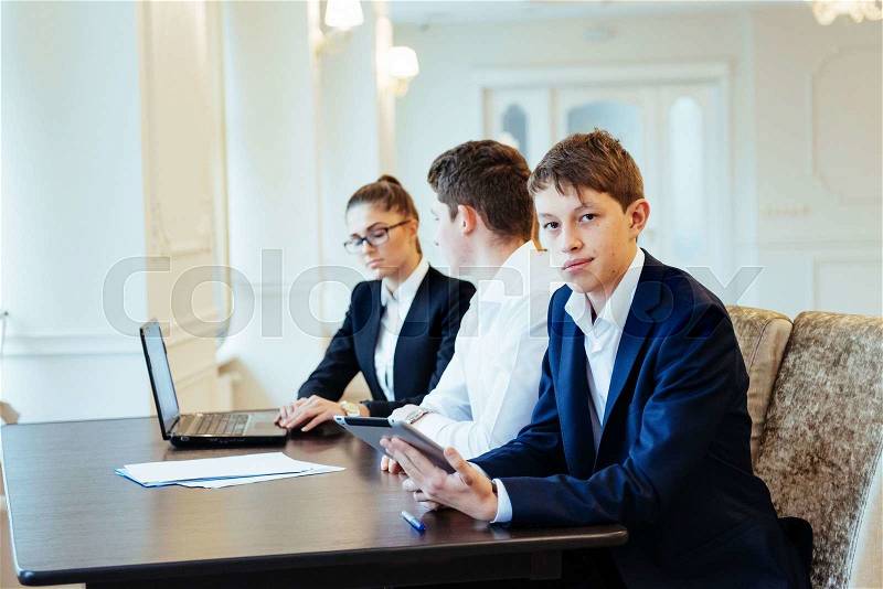 Students working together on tablet pc at the college, stock photo