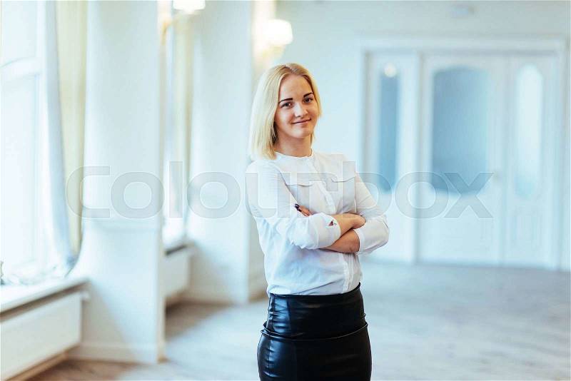 Happy business woman looking confident with modern building as background, stock photo