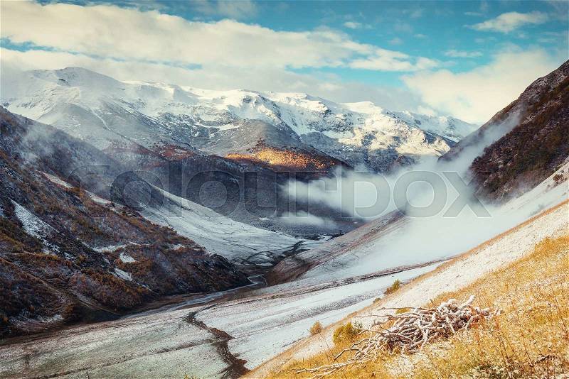 Mountain landscape of snow-capped mountains in the mist, stock photo