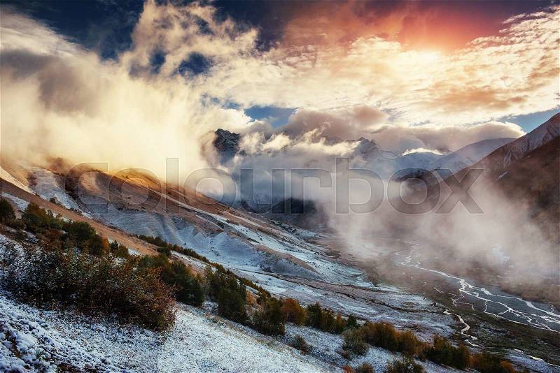 Mountain landscape of snow-capped mountains in the mist, stock photo