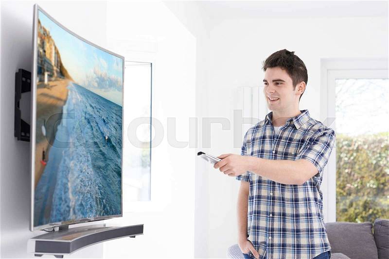 Young Man With New Curved Screen Television At Home, stock photo