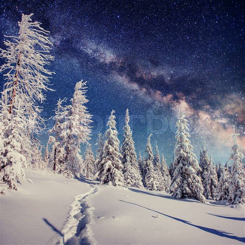 Starry sky in winter snowy night. fantastic milky way in the New Year's Eve. Starry sky snowy winter night. The Milky Way is a fantastic New Year's Eve. Winter road in the mountains, stock photo