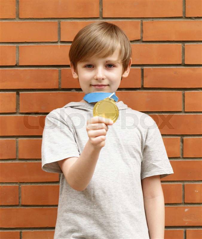 Blond boy is happy gold medal - champion, winner, stock photo