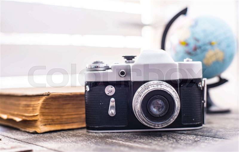 Rarity camera with globe and old book on the background, stock photo