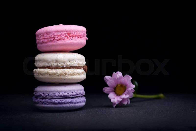 Delicious French dessert macarons on a black background, stock photo
