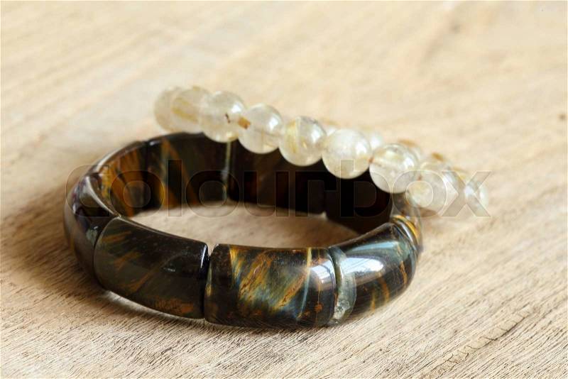 Lucky stone bracelets on wood background, closeup image, stock photo