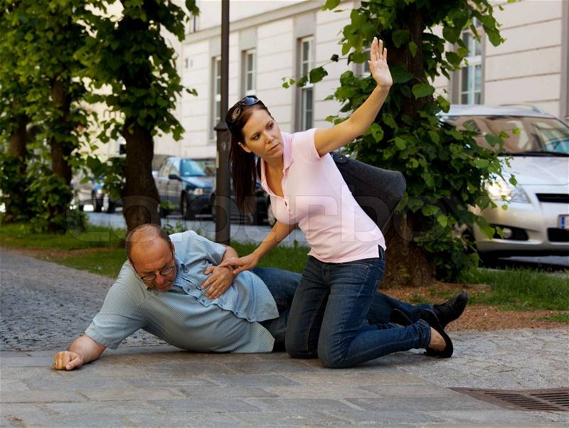 A man has a dizzy spell or a heart attack. Woman comes to the rescue, stock photo