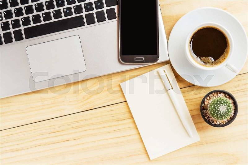 Open a blank white notebook with pen,smart phone, laptop and a cup of coffee on wooden table background. top view, stock photo