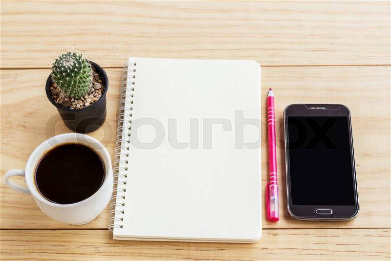 Vintage office desk table with notebooks,smart phone, pen and a cactus with cup of coffee. Top view with copy space. Business concept, stock photo