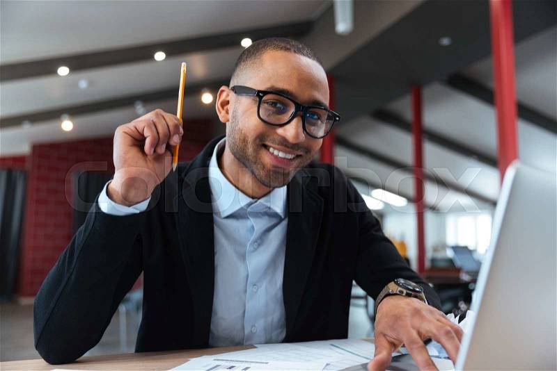 Clever businessman having a good idea holding a pencil, stock photo