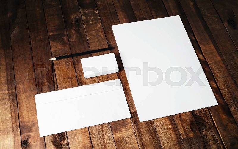 Blank stationery set on vintage wooden table background. Photo of blank letterhead, business cards, envelope and pencil, stock photo