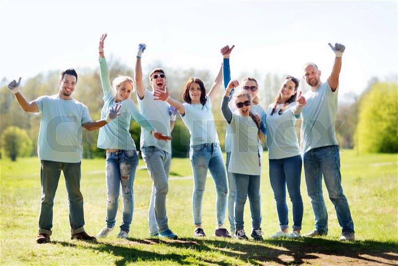 Volunteering, charity, people, gesture and ecology concept - group of happy volunteers showing thumbs up in park, stock photo
