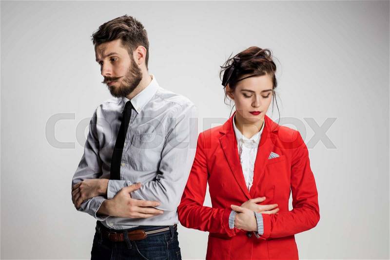 The funny sad business man and woman conflicting on a gray background. Business concept of relationship of colleagues, stock photo