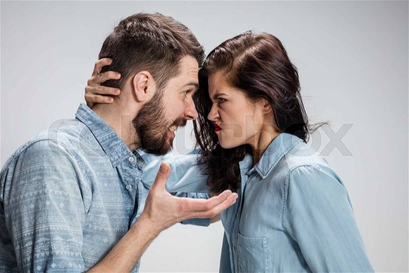 The young couple with different emotions during conflict on gray background, stock photo