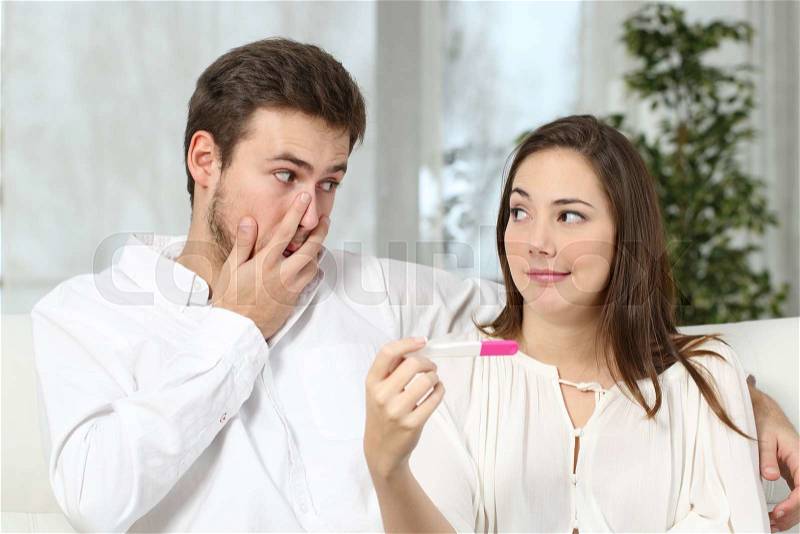 Worried couple or marriage looking each other making a pregnancy test at home. Contraceptive failure concept, stock photo